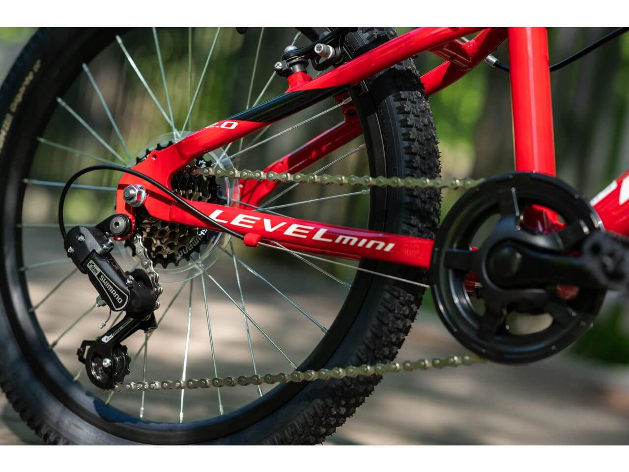 KR LEVEL MINI 2.0 fiets met rode frame en schakelsysteem, close-up van de ketting en derailleur.