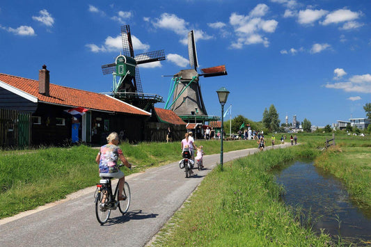 Fietsers genieten van de beste fietsroutes amsterdam 2026 langs molens en groen landschap.