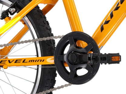Detail van de KR LEVEL MINI 2.0 fiets, met een focus op de ketting en pedalen in feloranje kleuren.