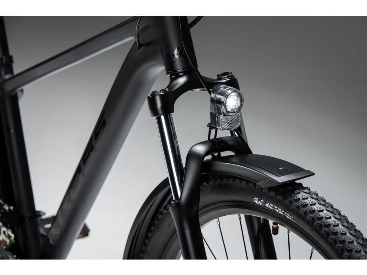 Details van de KROSS Hexagon X200 EQ mountainbike met zicht op de voorvork en verlichting.